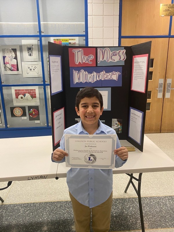Student shows award in front of poster